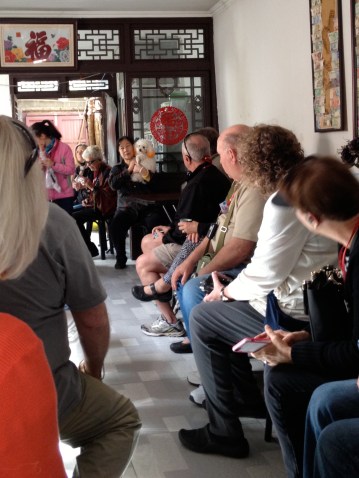 Our tour group crowds into a small hutong house. The owner is holding the dog.