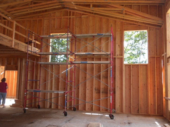 The living room. The fireplace will go about where the red scaffolding is, with cabinets on either side.