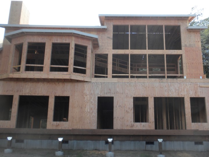 A front view of the main part of the house. Clockwise from upper left: dining room, living room, guest bedroom, master bedroom