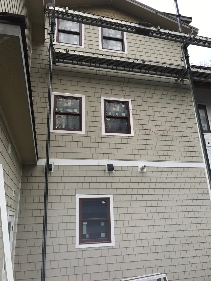 Siding complete on one section of the back of the house. If you look closely at the top, you can see fish-scale shingles.