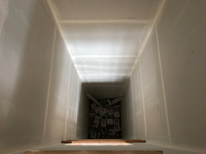 Looking down the elevator shaft, with empty drywall-tape boxes at the bottom