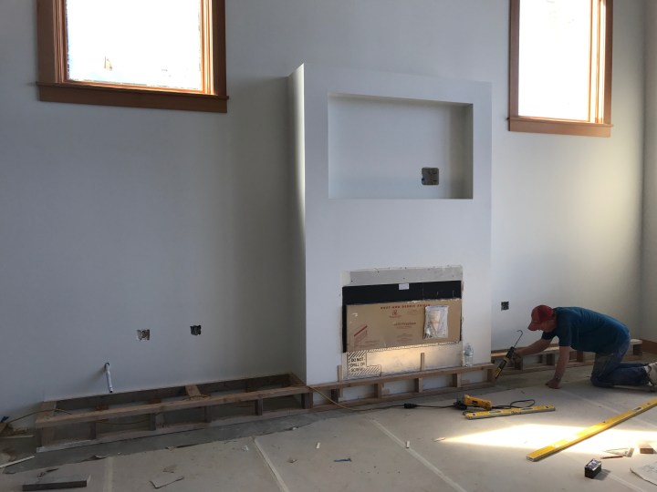 Tom the carpenter building the platform that will hold the hearth and cabinets around the living-room fireplace.